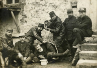 Groupe de sept militaires dans une pose humoristique : carte postale photographique noir et blanc (28 mars 1915).