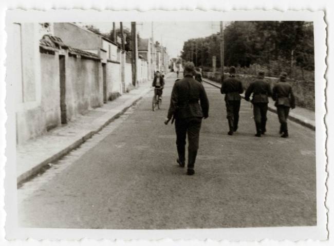 DRAVEIL.- Occupation de la ville par l'armée allemande : des soldats allemands marchant dans une rue bordant la forêt de Sénart.