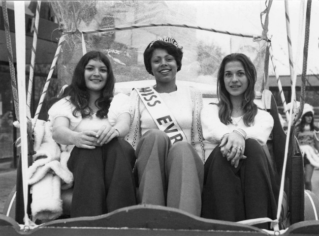 EVRY.- Miss EVRY 1973 dans un char fleuri en compagnie de deux jeunes filles, 1973, N et B. [deux exemplaires]. 