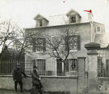 Deux militaires devant une maison d'habitation : photographie noir et blanc (28 mars 1915).