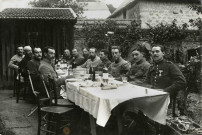 Groupe de douze militaires au repas : photographie noir et blanc.