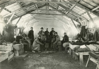Baraquement Adrian, intérieur, groupe de onze soldats autour d'un brasero : photographie noir et blanc.