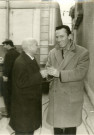Jean NOHAIN, et Philippe JOSSE dit Barberousse, en discussion à l'extérieur de la salle des fêtes, sans date, photographie, noir et blanc.