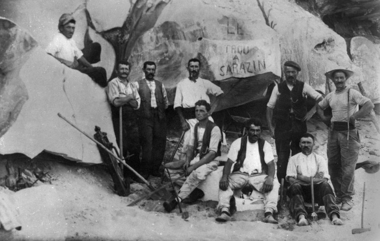 Groupe d'ouvriers posant dans une carrière, mention Le trou à Sarrazin sur un bloc de grés, 1920 