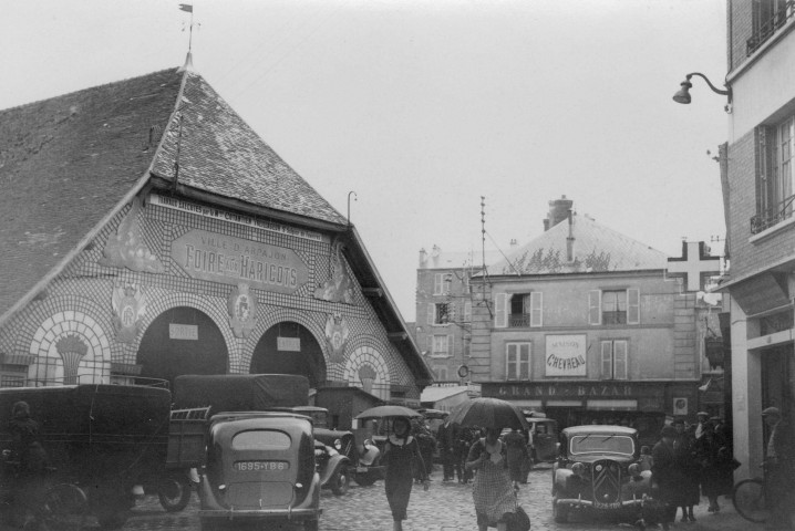 ARPAJON. - Foire aux haricots : la façade des halles décorée par M. Contentien, treillageur à Saint-Sulpice-de-Favières, [vers 1935], N et B. Dim. 11,5 x 17 cm. 