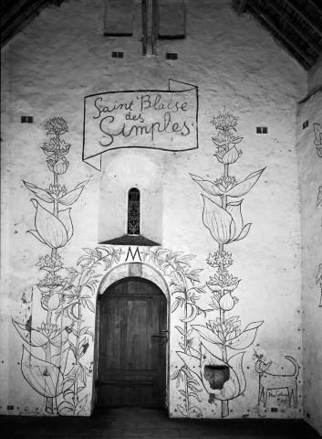 Mur intérieur (côté porte d'entrée), bénitier et fresque de la porte (menthe, gentiane, chat et signature de Jean COCTEAU), carte postale, noir et blanc, 1960.