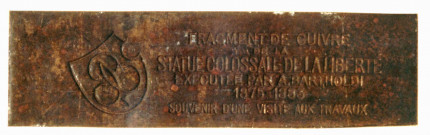 plaque commémorative : fragment de la statue de la Liberté éclairant le monde